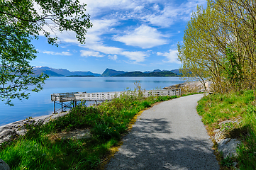 Image showing Serene morning stroll along idyllic seaside path amidst majestic