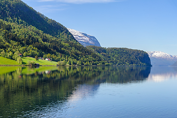 Image showing Serene morning reflection of snow-capped mountains on norwegian 