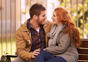 Image showing Couple, smile and sit on bench at park with affection in cold weather or winter, together and support in London. Relationship, commitment and bonding for romance with soulmate, care and happiness
