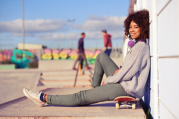 Image showing Portrait, happy woman and skateboard in city by wall in summer for sport, fashion or relax outdoor. Smile, skate park and gen z girl or young person in casual clothes with headphones in South Africa
