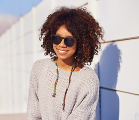 Image showing Woman, smile and portrait in city for travel, walk and break in urban for summer, fun and outdoor. African person and happy with glasses for sun, streetwear and journey in town for trip and trendy