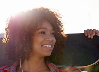 Image showing Face, black woman and smile with skateboard, outdoor with sunshine or lens flare to think, vision and happy. Closeup, female person and skater with hobby or activity for training, fun and relax