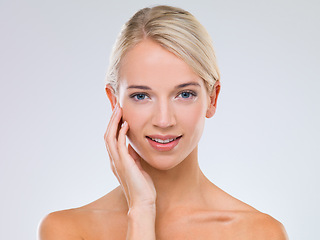 Image showing Woman, skincare and wellness in studio portrait with hand on face for results, touch and natural by white background. Girl, person and model with cosmetics, facial glow and transformation with smile