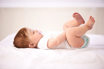 Image showing Relax, baby and playing on bed for care, calm kid and diaper comfort in nursery with pacifier. Child development, girl infant in family home for nap time, wellness growth and resting in bedroom