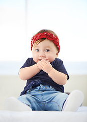 Image showing Portrait, sitting and bed for baby fashion in family home, cute and trendy street style on curious girl toddler. Creative, child development and growth, adorable headband accessory with funky clothes