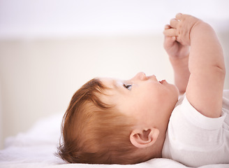 Image showing Girl, baby and laying on bed with thinking for childhood development, growth and relax in bedroom. Newborn, infant and kid with curiosity for knowledge, peace or waking up in nursery at home