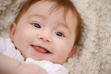 Image showing Happy, cute and portrait of baby on blanket playing for child development and positive face. Smile, sweet and closeup of girl kid, infant or newborn relaxing and laying on bed in nursery room at home