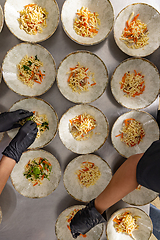 Image showing Close-up of a chef's hands arranging food