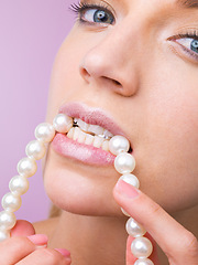 Image showing Woman, studio and bite pearl necklace in portrait for beauty, cosmetic or closeup by purple background. Girl, person and model with jewelry for wellness with facial skincare, makeup or transformation