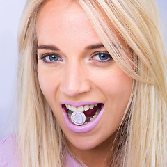 Image showing Woman, beauty and studio portrait with candy in mouth with makeup, lipstick or heart sign by purple background. Girl, person and model in closeup with sweets, emoji or happy for eating with cosmetics