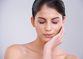 Image showing Woman, relax and face with skincare, cosmetics or facial treatment on a gray studio background. Young female person, brunette or model with smile in satisfaction for beauty, makeup or spa on mockup