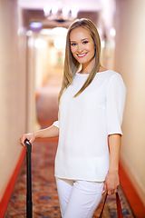 Image showing Luggage, travel and portrait of woman in hotel for holiday, vacation and weekend in accommodation. Happy, fashion style and person with bag in resort, lodge or room for journey, trip and adventure