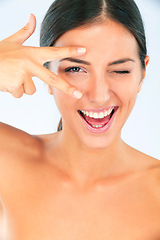 Image showing Peace hands, skincare and portrait of happy woman with wink in studio for wellness on white background. V, eyes and female model smile for dermatology, shine or natural cosmetic, treatment or results