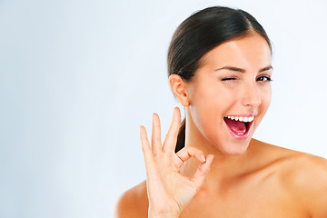 Image showing Woman, portrait and OK hand gesture for beauty, happy with wink and skincare feedback or vote on white background. Mockup space, flirt and cosmetic care with playful model and dermatology approval