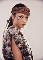 Image showing Portrait, girl and Native American culture in studio with warrior makeup, confidence and tribe style. Indigenous fashion, face paint and serious woman in First Nations clothes on white background