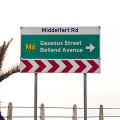 Image showing Road sign, intersection and direction in city with arrow for grammar, mistake or text for gas for driving in neighborhood. Buildings, error and funny signage with joke, fart and warning in Cape Town