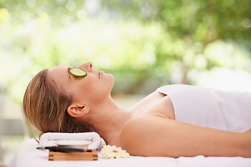 Image showing Woman, massage and spa with cucumber treatment for skincare facial or wellness, detox or stress relief. Female person, eyes closed and calm on table at zen resort for luxury, peace or comfortable