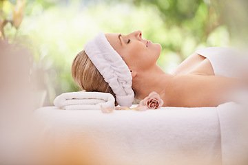 Image showing Woman, spa and break for zen, peace and wellness with relaxation and calm. Lady, towel and massage table at resort, lounge or luxury parlor with rose for holistic body and skincare for detox and rest