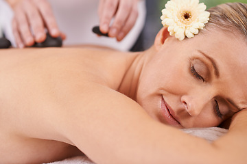 Image showing Woman, spa and hands with hot stone for massage, wellness and relax in hotel. Physical therapy, holistic and female person in holiday or vacation in California for health, peace and back skin detox