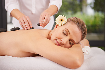 Image showing Person, spa and hands with hot stone for massage, wellness and relax in hotel. Physical therapy, holistic and woman or girl in holiday or vacation in California for health, peace and back skin detox