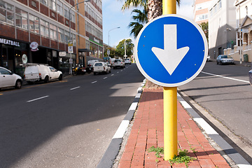 Image showing Road sign, blue arrow and signage in street for direction with attention notification and symbol outdoor in city. Board, public notice and signpost for driver, alert message and advertisement in town