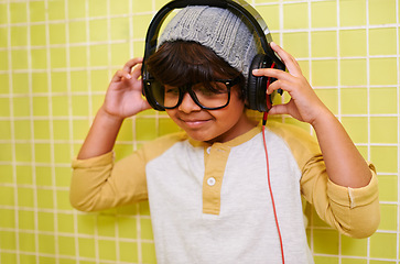 Image showing Child, music and glasses with headphones in bathroom with song in a home. Radio, eyewear and youth fashion with a hipster boy listening to audio with with cool style in a house with spectacle frames