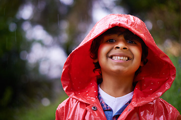 Image showing Rain, coat and portrait of boy in a forest for adventure, freedom or exploring games in nature. Winter, travel and face of excited kid in India outdoor for learning, journey or freedom in a storm