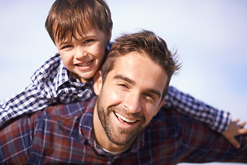 Image showing Portrait, man and child with piggy back, smile and playful travel to relax on outdoor adventure. Support, face of father and son in nature for fun bonding, playing and happy trust on holiday together