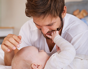 Image showing Happy, love and baby with father on bed relaxing, playing and bonding together at home. Smile, sweet and young dad laying with girl child, infant or kid in bedroom or nursery at family house.