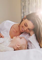 Image showing Mother, playful and care with baby on bed for bonding, love and relaxing together in bedroom. Lens flare, happy woman and daughter for childhood development, support and nursery in apartment