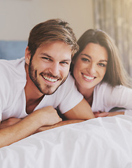 Image showing Smile, hotel and portrait of couple on bed for relaxing, bonding and resting together on vacation. Happy, romantic and young man and woman laying in bedroom at modern apartment or home on weekend.