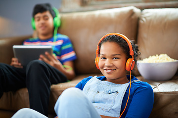 Image showing Tablet, children and portrait of girl with headphones in streaming, music or audio book with her brother at home. Kids, family and siblings in living room with digital, app or radio, relax or bonding