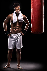 Image showing Sport, boxer and man with towel in studio with gloves for training with strength and muscle. Adult, athlete and male person in dark background, healthy and power with body, punching bag and tired