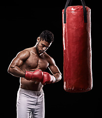 Image showing Hands, boxing bag and gloves for male boxer, studio and athlete on black background. Dark, training and combat sports or MMA for man model, workout, muscle and impact activity for martial arts