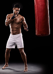 Image showing Kickboxing, man or training in studio with punching bag for workout, exercise or competition fight with fitness. Athlete, boxing or serious for martial arts with muscle or topless on black background