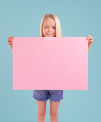 Image showing Child, portrait and poster mockup in studio as billboard presentation for placard on blue background, announcement or board. Female person, face and smile or information banner, contact us or paper
