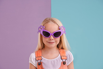 Image showing Girl, child and sunglasses with fashion for style, funky clothes and colour block background. Confidence, young kid and groovy face accessory in studio with smile, happiness and trendy outfit