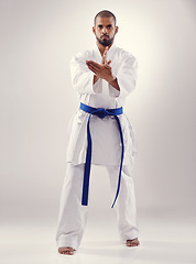 Image showing Studio, karate and black man training for power for physical health with fitness and effective technique. White background, male person and adult with disciple of martial arts, sport and blue belt