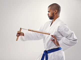 Image showing Man, karate and belt for martial art, sport and strength for fight and strong for technique and power in studio. African person and focus with tool for train, defend and recreation for active