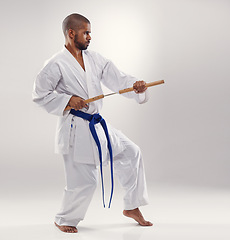 Image showing Karate, fight and man with nunchucks in martial arts, studio or training with weapon for defence on white background. Nunchaku, exercise and fighting with equipment in sport with skill and power