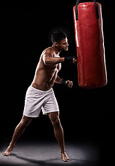 Image showing Boxing, man and training in studio with punching bag for workout, exercise or competition fight with fitness. Athlete, boxer and confidence for martial arts with energy or topless on black background