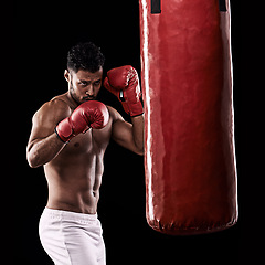 Image showing Workout, boxer and man in studio with punching bag for training with strength and muscle. Adult, athlete and male person in dark background, healthy and power with body, fitness and sport for job