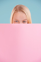 Image showing Child, portrait and poster mockup in studio for information opinion with announcement, presentation or blue background. Female person, face and billboard placard with space, banner or development