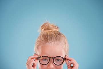 Image showing Child, portrait and glasses in studio for vision optometry on blue background for frames, wellness or mockup space. Girl, kid and face with eyewear healthcare for sight spectacles, lens or optical