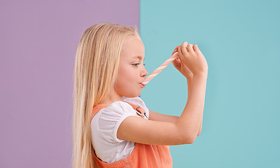 Image showing Child, candy and eating dessert in studio for unhealthy snack or sugar meal, sweets or mockup space. Female person, food and split purple with blue background for party or lollipop, treat or hungry