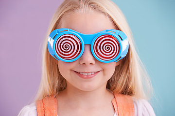 Image showing Child, background and colour with fashion glasses, happy smile on girl with hypnotic eyewear in studio. Groovy, funky and playful hipster style, trendy kid with cool vibrant pattern for accessories