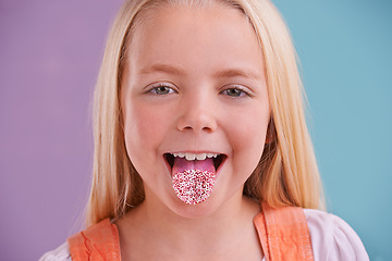 Image showing Child, portrait and tongue out in studio for crazy, silly and playful facial expression with color block background. Happy, goofy and funny face of young girl for comic, humor and joking by sprinkles