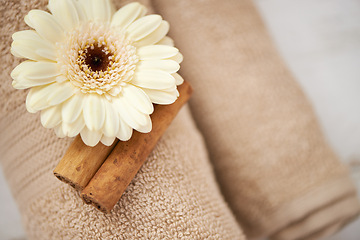 Image showing Detail, closeup and flower on towel in spa for luxury service in hospitality at hotel on holiday or vacation. Floral, cinnamon and offer object in accommodation for wellness treatment on table