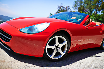 Image showing Luxury, sports car and driving closeup with wheel in city, outdoor in summer and person on road trip. Red, convertible and rich driver with transport to travel on highway and vehicle on street