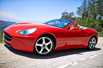 Image showing Luxury, car and woman on a drive in city, outdoor in summer with happiness on road trip. Red, convertible and motor transport of rich driver to travel on highway of hill with vehicle on street